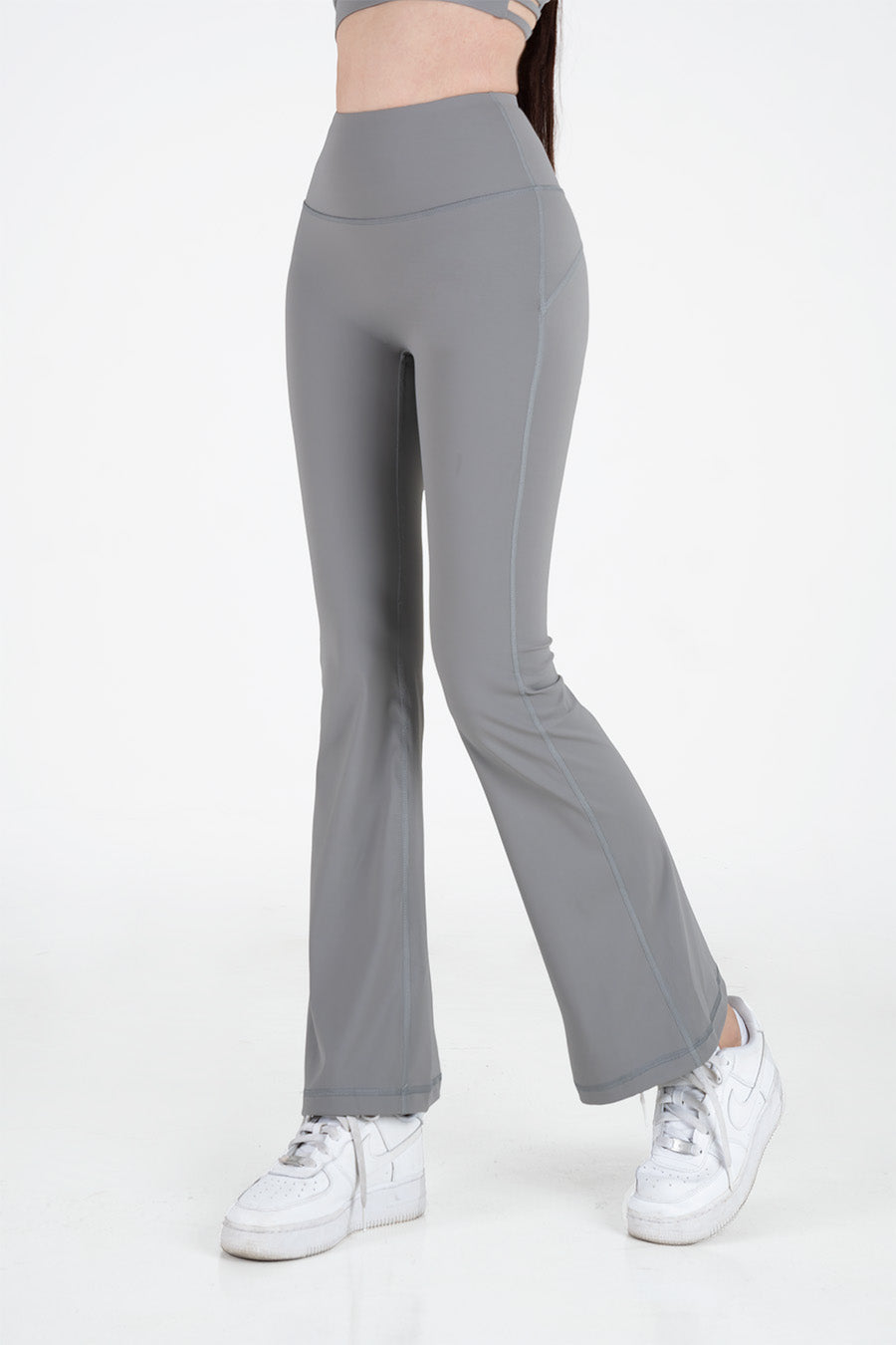 Nàng mặc quần legging cạp cao màu ghi đậm trong tư thế squat trọng lượng cơ thể tại phòng tập